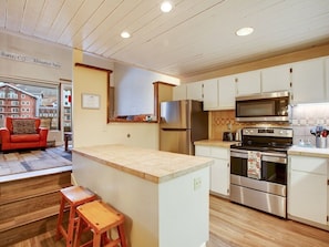 Enjoy cooking in this well-equipped kitchen with a refrigerator, microwave, and oven, plus a convenient island with stools.