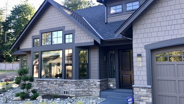 A modern two-story house with a stone foundation, large windows, and a garage. - Woodinville Wine Country New Custom Home - Seasonal Pricing - Casa Bambino (Woodinville)
