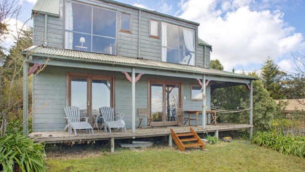 A two-story house with a porch, large windows, and outdoor seating. - Stunning Cliff Face and Valley Views (KATOOMBA)