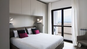 Een moderne hotelkamer met een groot bed, uitzicht door een schuifdeur en een stoel bij het raam.