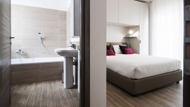Een moderne badkamer met een bad, wastafel en douche.
