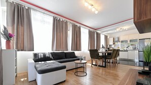 Una sala de estar moderna con un sofá, una mesa redonda de centro y un comedor con sillas y una mesa.