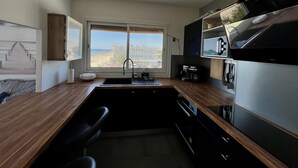Een moderne keuken met een groot raam, een inbouwoven en een spoelbak.