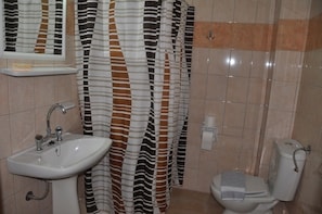 A bathroom with a striped shower curtain, a sink, and a toilet.