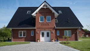 A two-story brick house with a symmetrical facade, a central entrance, and a paved driveway. - Apartment Alma - Apartment Lühe (Jork)