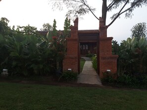 A brick archway leading to a building with a tiled roof.