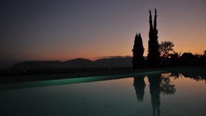 Un espace piscine paisible offrant une vue dégagée sur les montagnes lointaines et un magnifique coucher de soleil.