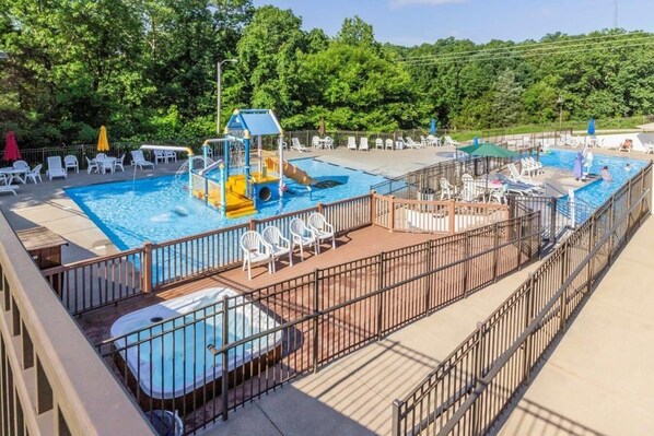 Relax by the pool surrounded by lush greenery and enjoy the hot tub and lounge chairs.