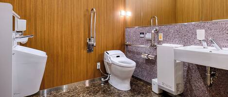 Une salle de bain moderne équipée de toilettes, d’un bidet et d’un lavabo.