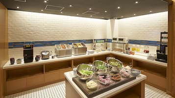 A buffet setup with various food items and a coffee machine.