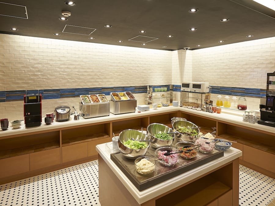 A buffet setup with various food items and a coffee machine.