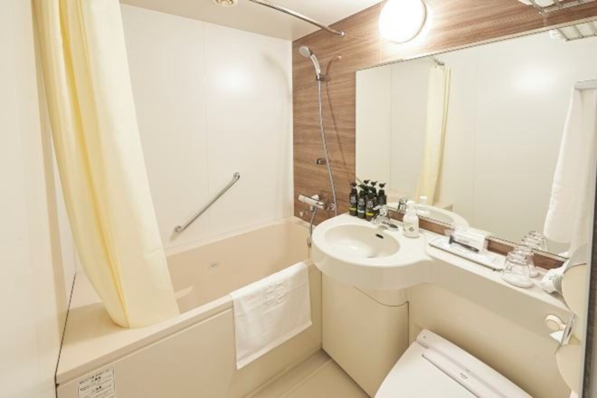 Un bagno moderno con vasca, lavandino e specchio.