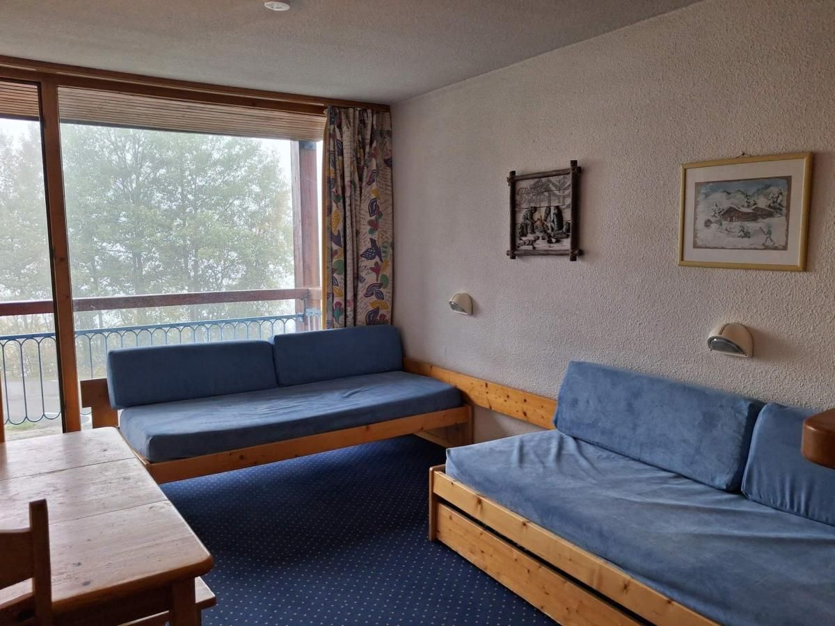 Ein Zimmer mit einer Holzbank, einem Sofa und einem Tisch.
