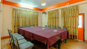 A conference room with a long table, chairs, and curtains. - Hotel River Holiday Inn (Kathmandu)