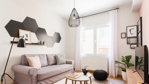 Ett modernt vardagsrum med en soffa, ett soffbord och en hängande lampa.