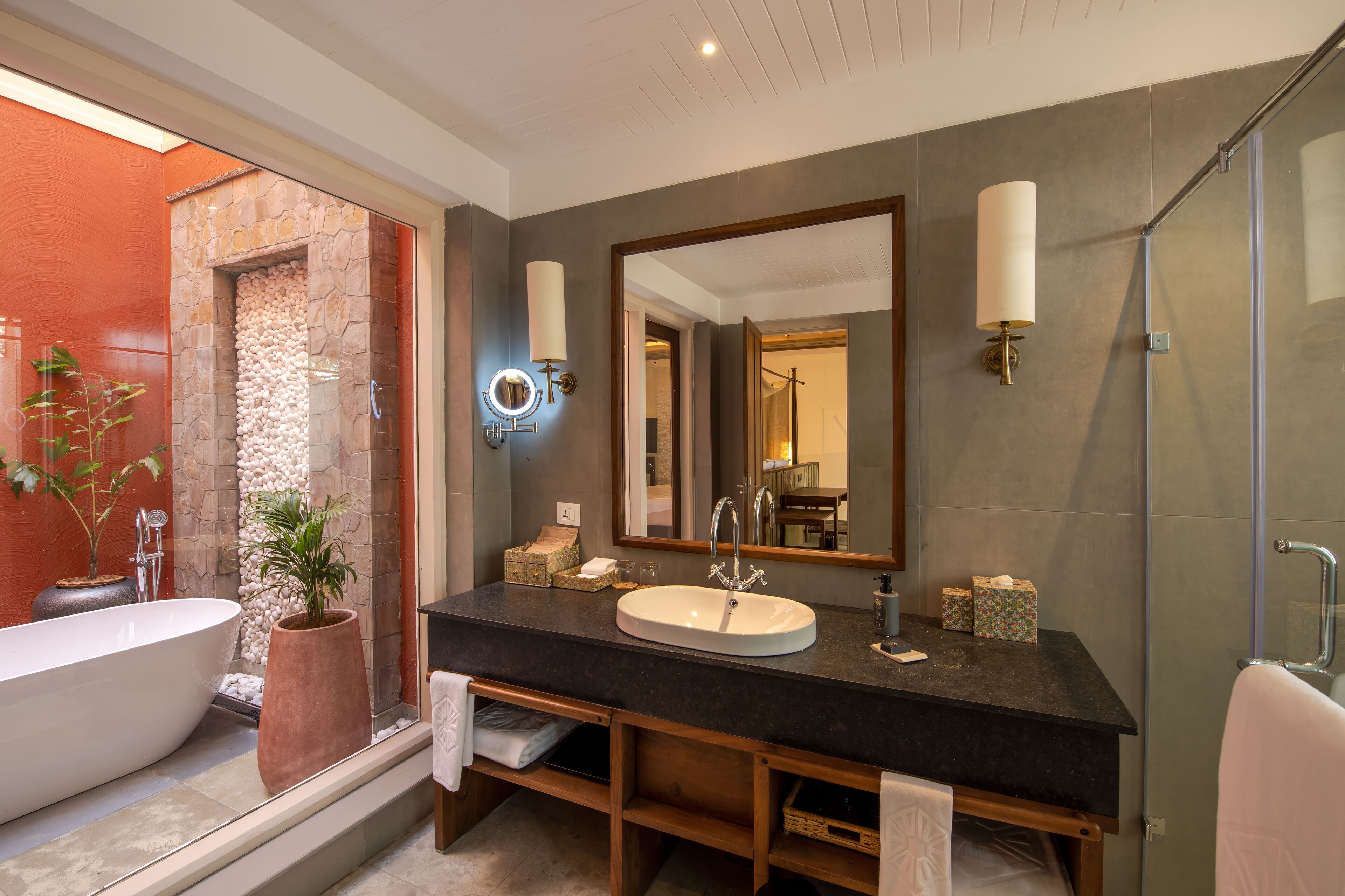 A modern bathroom with a freestanding bathtub, a large mirror, and a glass shower enclosure.