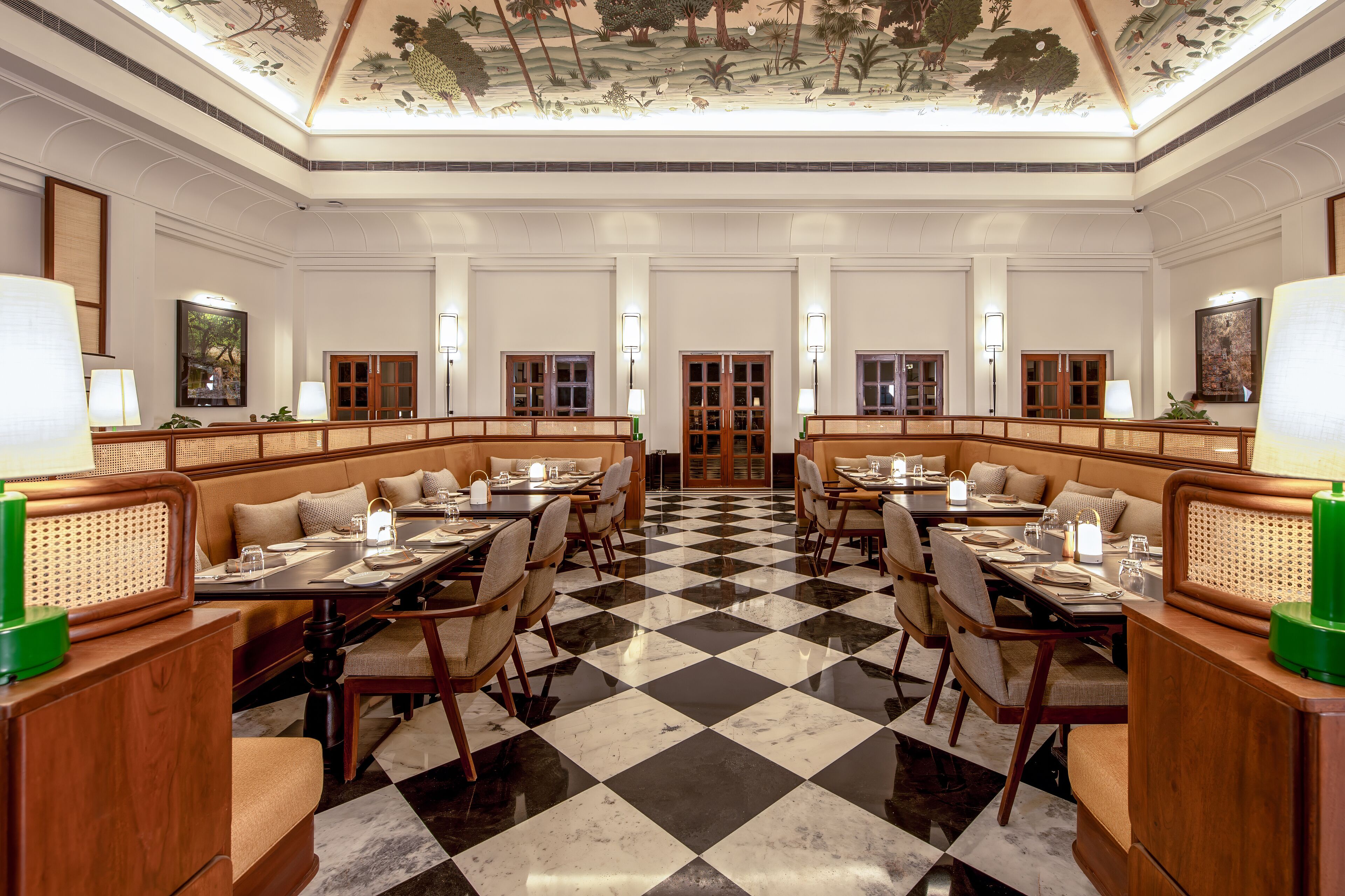 A hotel dining area with checkered flooring, wooden tables, and cushioned seating.