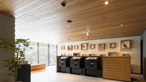 A modern reception area with wooden ceiling panels, a large potted plant, and a series of framed pictures on the wall. - JR East Hotel Mets Premier Tokyo Bay Shinkiba (Tokyo)
