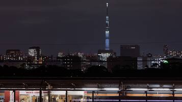 A nighttime cityscape with a prominent tower lit up against the sky.