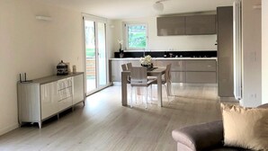 Een moderne keuken met een eethoek, een bank en een schuifdeur naar een balkon.