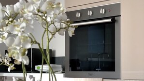 Een moderne keuken met een inbouwoven en een decoratieve orchidee.