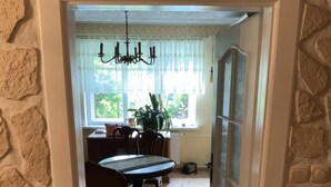A doorway leading to a dining area with a table, chairs, and a chandelier.