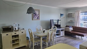 Una sala de estar con comedor, televisor y sofá.