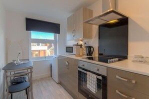 Departamento Premium, 1 cama matrimonial y sofá cama, vista parcial al mar | Cocina privada | Refrigerador, microondas, horno y parrilla de estufa 