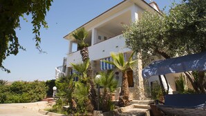 A two-story building with a balcony, surrounded by greenery and a clear sky. - Villa Eden Luxore (SCIACCA)