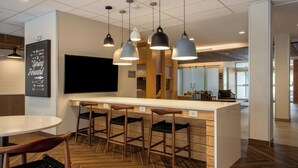 A modern kitchen with a central island, bar stools, and pendant lighting. - Fairfield Inn & Suites by Marriott Greenville Spartanburg/Duncan (Duncan)