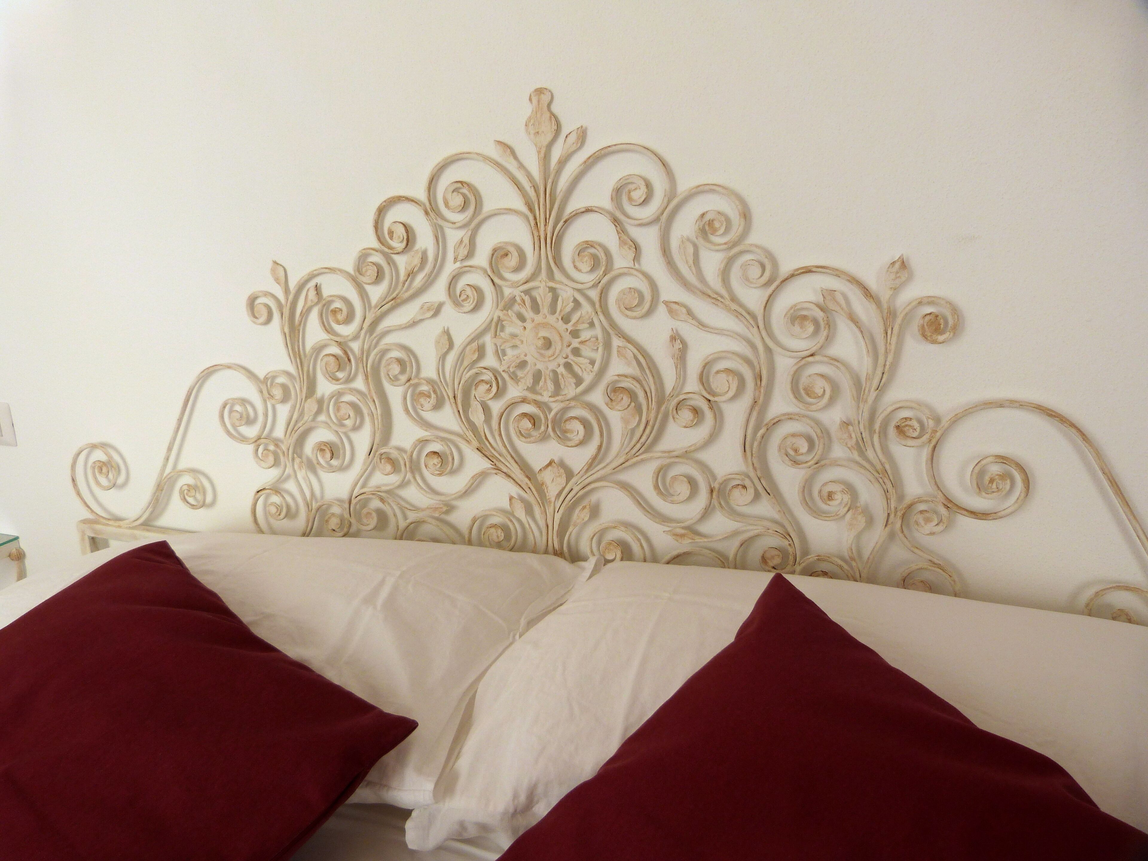 A bed with a decorative headboard and two pillows.