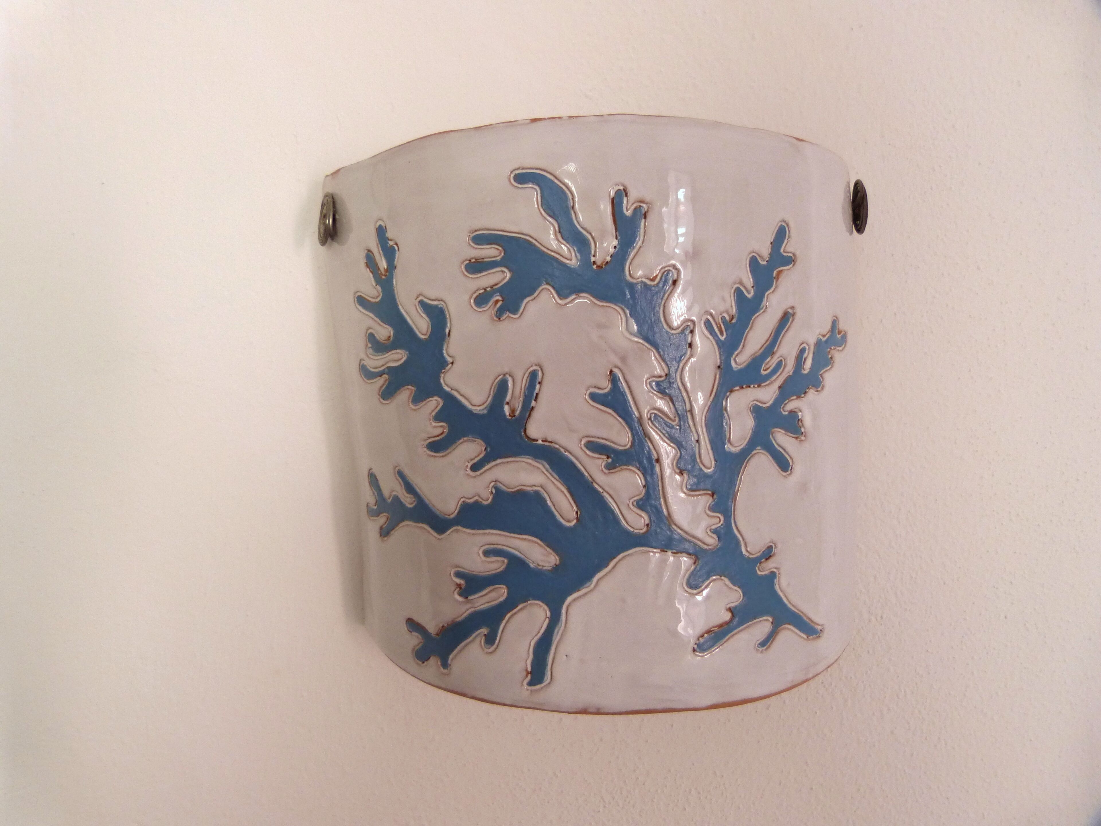 Una taza de cerámica con un diseño de árbol azul.