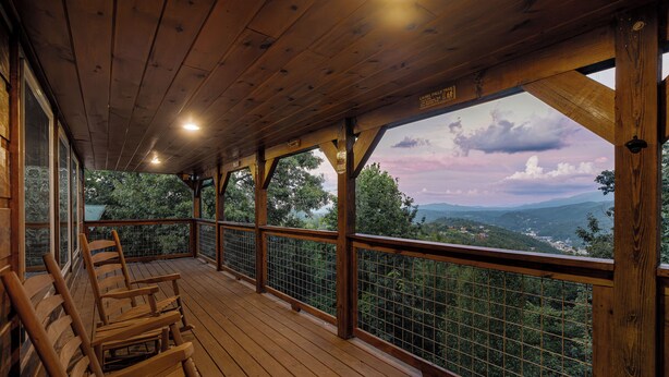 A wooden deck with chairs and a view of a mountainous landscape. - Free Attractions Pvt Pool, Mtn and City views. View fireworks from Hot tub! (Gatlinburg)