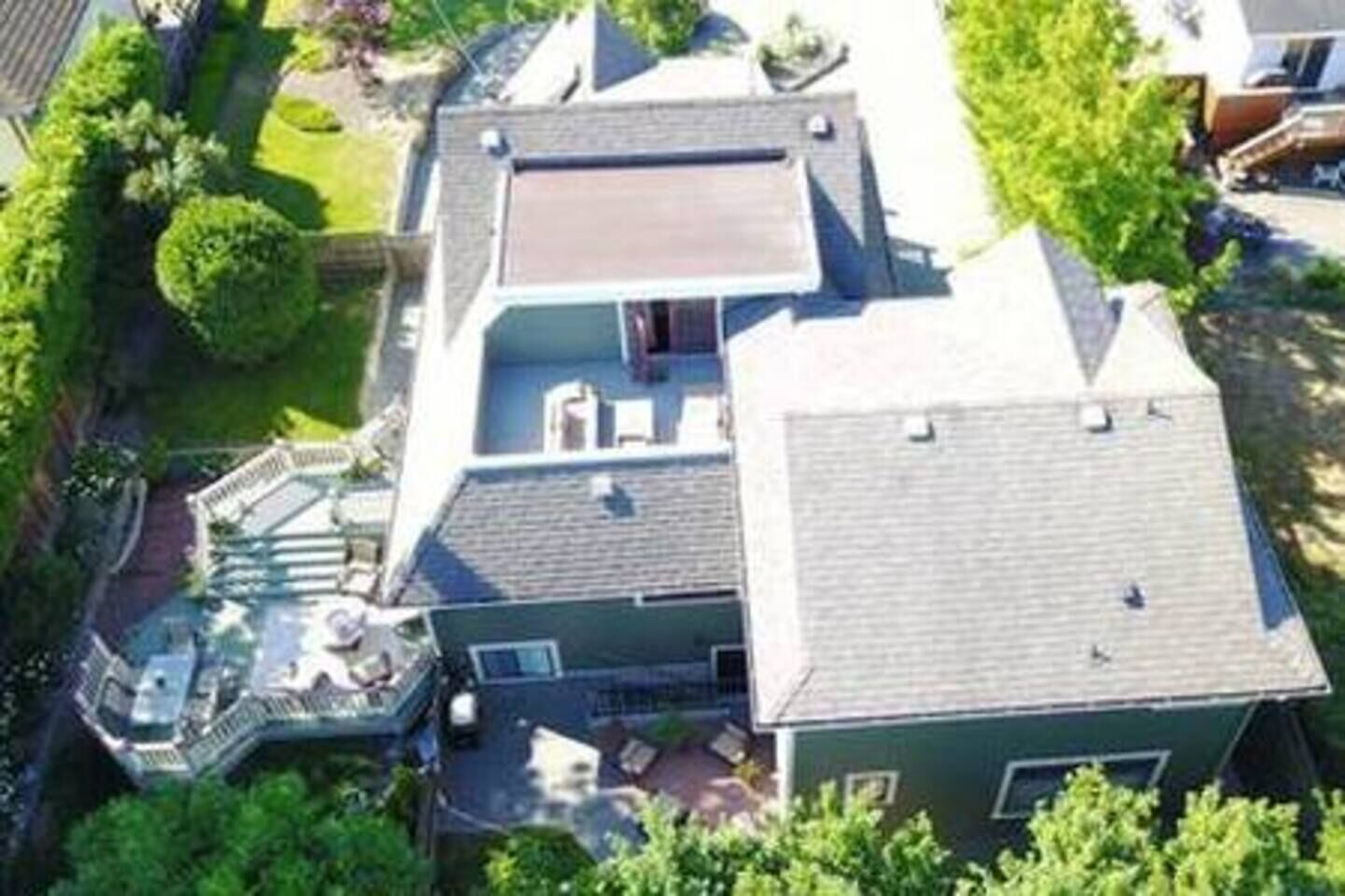 A two-story house with a covered patio and a swimming pool.