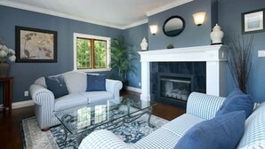 A living room with a fireplace, a sofa, and a coffee table. - Character Stay across Swan Lake Nature Sanctuary (Victoria)