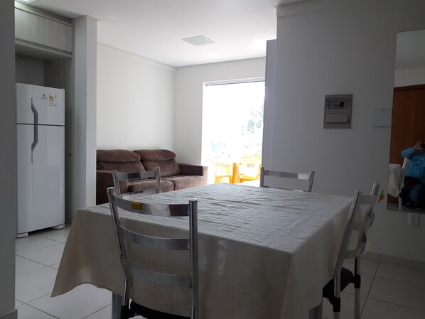 Cozy living space with a dining area, featuring a sofa, dining table, and kitchenette.