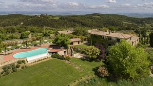 A villa with a swimming pool, surrounded by lush greenery and hills. - Villa Dipendenza, Historic Holding with  wonderful swimming pool (murlo - siena, tuscany)