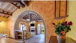 A rustic interior with a wooden table, a sofa, and a fireplace. - Villa Dipendenza, Historic Holding with  wonderful swimming pool (murlo - siena, tuscany)