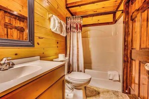 A wooden bathroom with a sink, toilet, and bathtub. - Pools Rush Inn (Cosby)