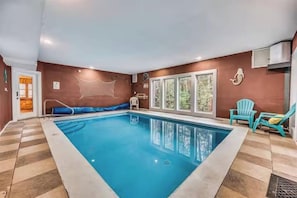 An indoor swimming pool with a clear view of the surrounding walls, a window, and a chair. - Pools Rush Inn (Cosby)