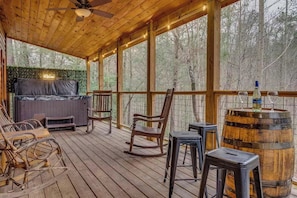 A wooden deck with outdoor seating, a hot tub, and a view of the forest. - Pools Rush Inn (Cosby)