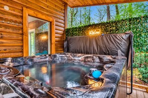 A hot tub with a wooden exterior, a neon sign, and a view of trees. - Mountain Retreat • Sleeps29 • Pool • HotTub • Dogs (Cosby)