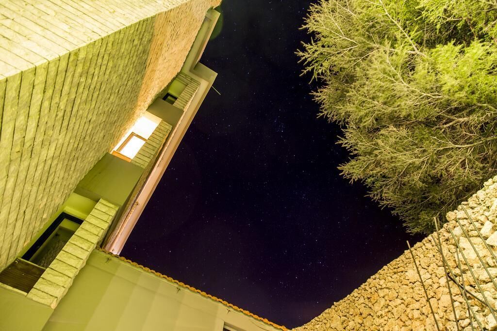 A night view of a building with a starry sky visible through a window.