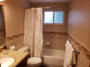 Bañera con ducha, secador de pelo, toallas, jabón