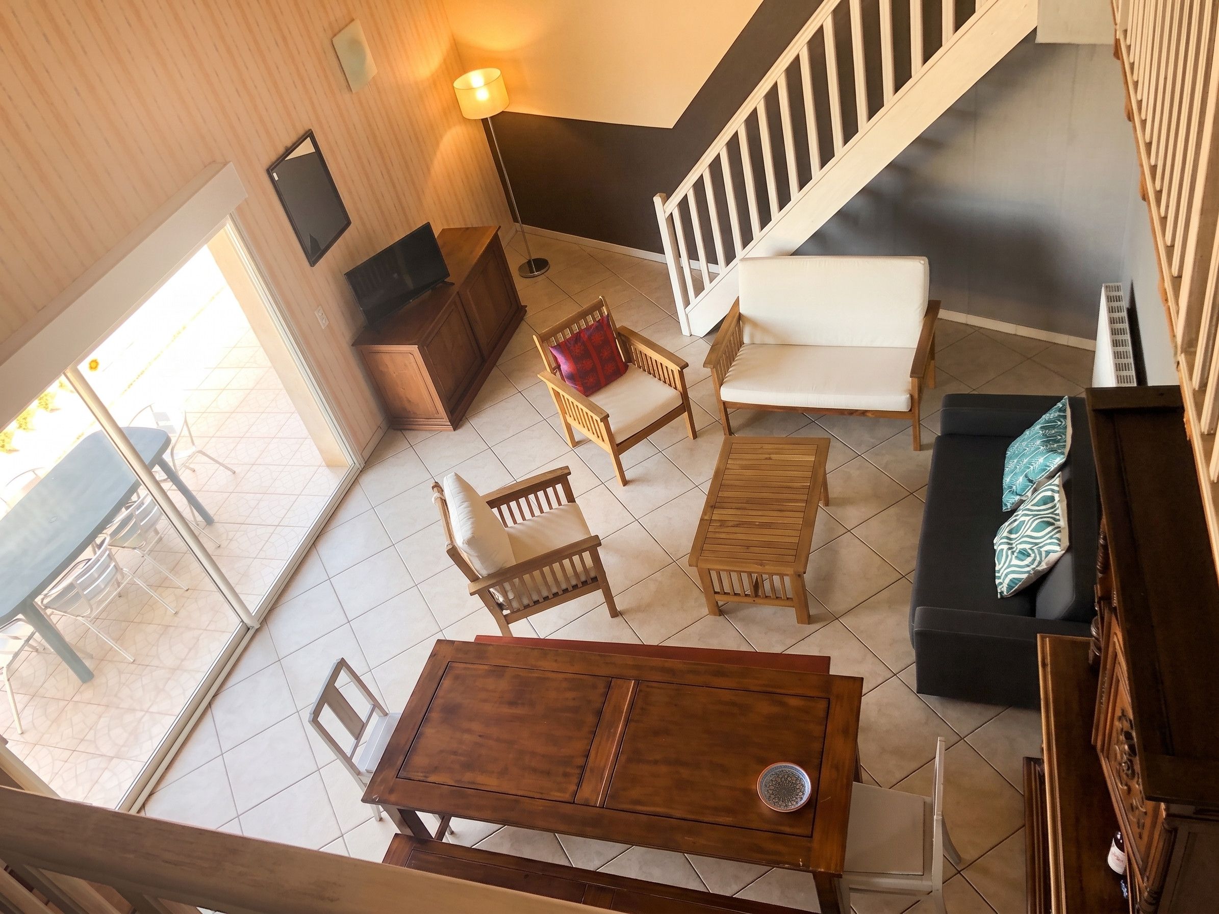 A spacious living area with a wooden table, a sofa, and a chair.