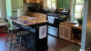 A kitchen with a wooden ceiling, a green refrigerator, a stove, and a bar stool. - 24 - Funky and charming, 'small house' in West Tremont (Tremont)