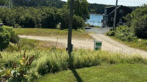 A rural landscape with a dirt path leading to a house by a lake, surrounded by greenery. - 24 - Funky and charming, 'small house' in West Tremont (Tremont)