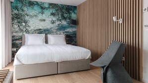 A modern bedroom with a bed, a wall mural, and a unique chair. - Hotel Majer'ca (Bohinj)