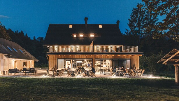 A two-story wooden building with a balcony and outdoor seating area. - Hotel Majer'ca (Bohinj)