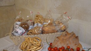 A table with various food items including pretzels, bread, and cherry tomatoes. - In & Out Matera (Matera)